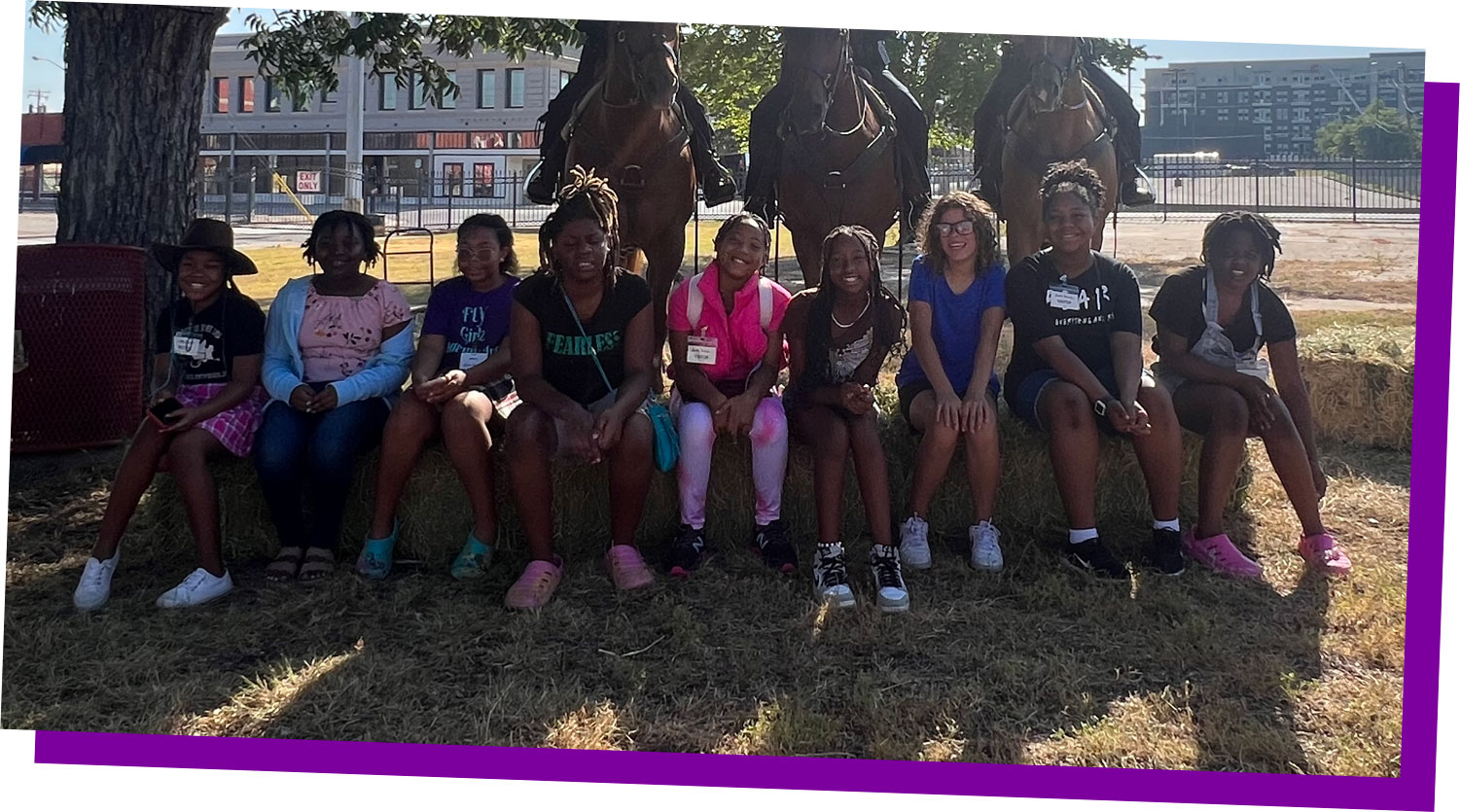 The Fort Worth Mounted Patrol poses on horseback with the group of young leaders for a photo.